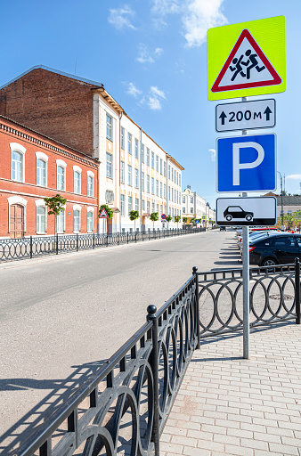 Borovichi, Russia - August 29, 2021: City street with parking lot and road signs in summer sunny day