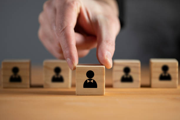 istock Man holds wooden cube with person 1371967776