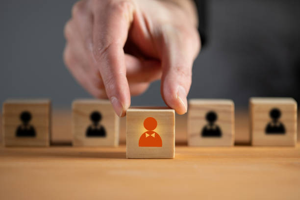 istock Man holds wooden cube with person 1371967779