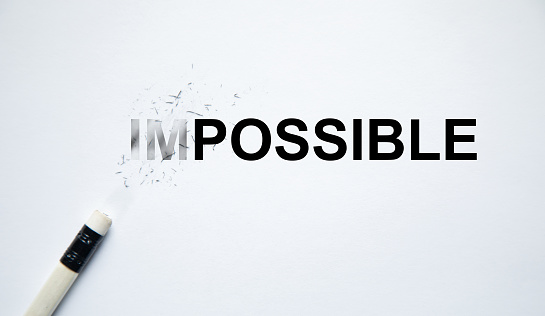 Changing the word impossible to possible with a pencil eraser.