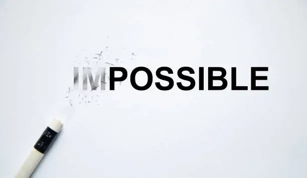 Changing the word impossible to possible with a pencil eraser.