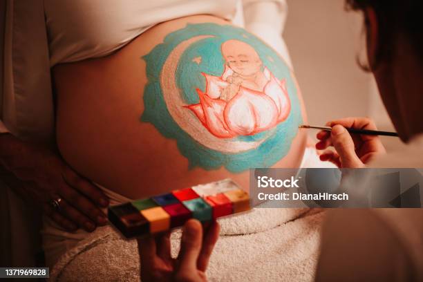 Close Up Of The Fathertobe Painting The Pregnant Belly Of His Beloved Wife Painting A Baby Girl Sitting In A Lotus In The Centre Of A Mandala Stock Photo - Download Image Now