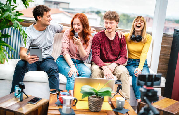 istock Trendy milenial people having fun on streaming platform with web cam - Content marketing concept with millenial guys and girls sharing live vlog feeds at modern open space office - Bright vivid filter 1371969917