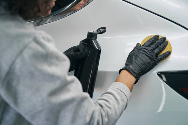 istock Worker in nitrile gloves waxing client motorcar 1371972680