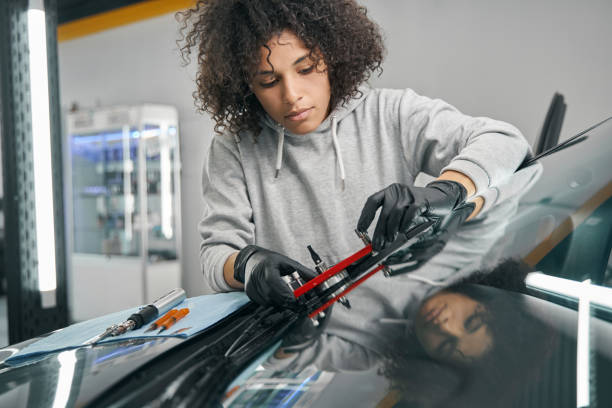istock Serious mechanic installing bridge for windshield before injecting resin 1371972697