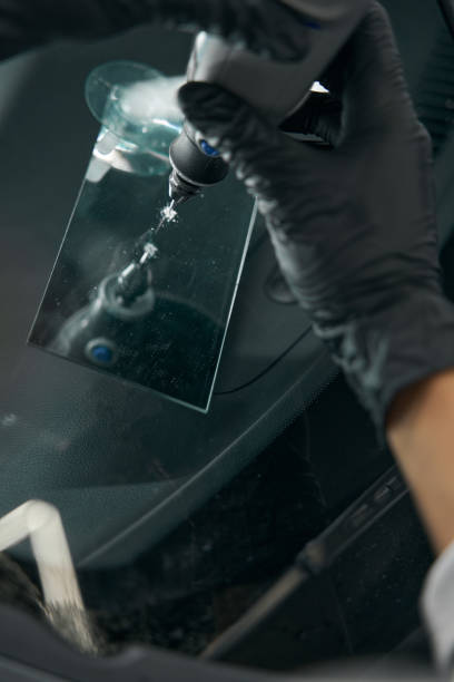 istock Experienced repair technician fixing crack on car windscreen 1371972698