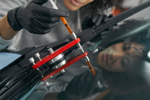 istock Experienced auto shop mechanic repairing scratched windshield 1371972713