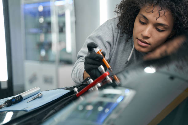istock Concentrated skilled worker repairing damaged windshield on customer car 1371972718