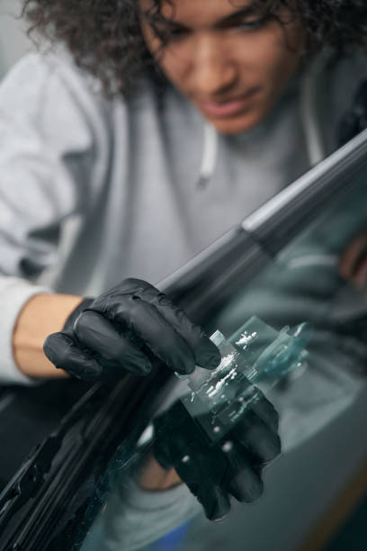istock Car detailing professional removing glass debris from crack site 1371972726