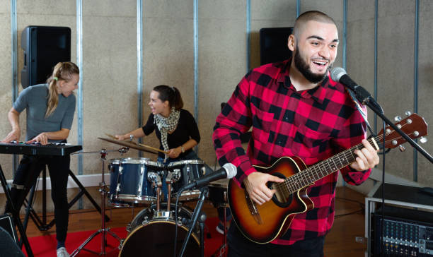 istock Guy guitar player and singer practicing with band members in re 1371975889