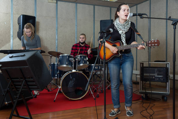 istock Pretty guitar player and singer with band 1371975891