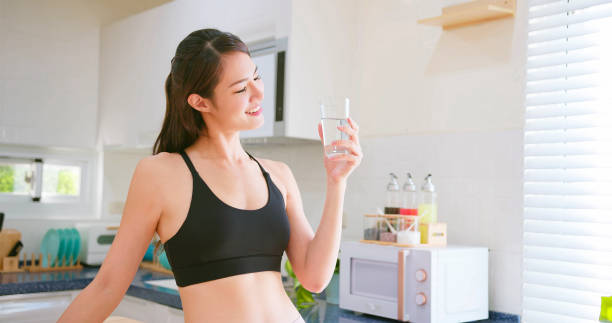 woman drinking water asian fitness woman drinking water in kitchen at home drinking water stock pictures, royalty-free photos & images