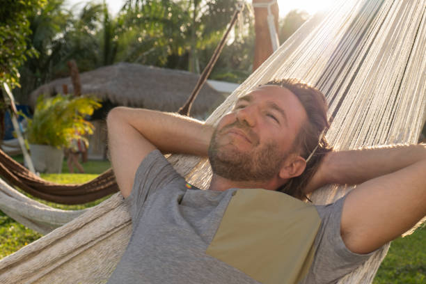 istock Man relaxing in an hammock at sunset, garden view 1371977499
