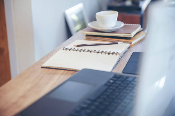 istock Diary and Planner Book on School table for Student, study for exam. Wooden desk with laptop, tablet, notebook, cup of coffee, and pencil. Desk for student work at home concept. 1371978352