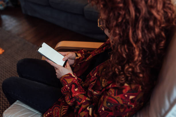 istock Woman using her phone at home 1371979559