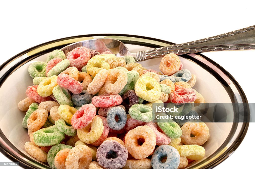 White Bowl with Cereal Top close-up of round loops of multicolored cereal with spoon sit in bowl... one loop on table. Bowl Stock Photo