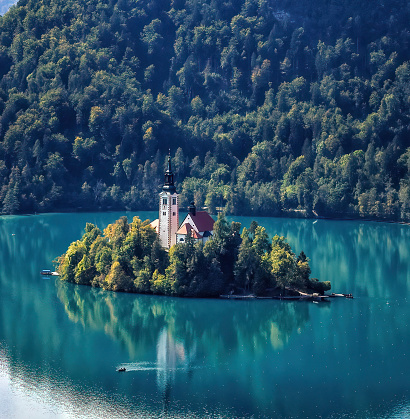 The lake surrounds Bled Island The island has several buildings, the main one being the pilgrimage church dedicated to the Assumption of Mary