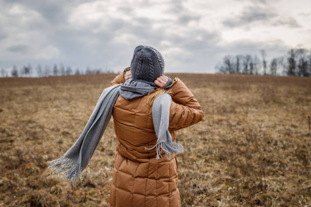 Wind and cold weather. Woman wearing warm clothing stock photo