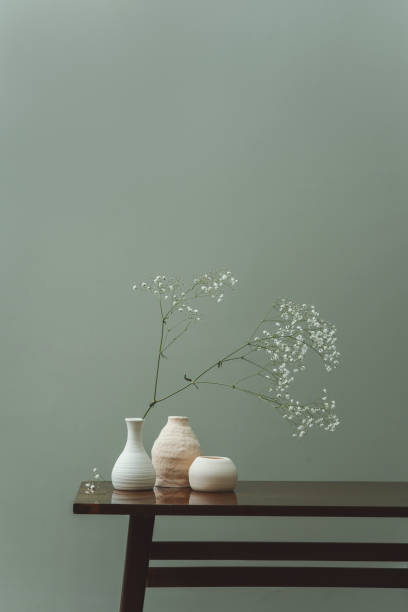 istock Minimalistic still life of ceramic vases with flowers on table 1371983536