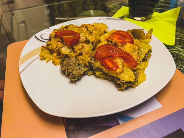 Oven potatoes with meat tomatoes and cheese gratinated.