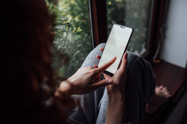 istock Woman using her phone at home 1371983736