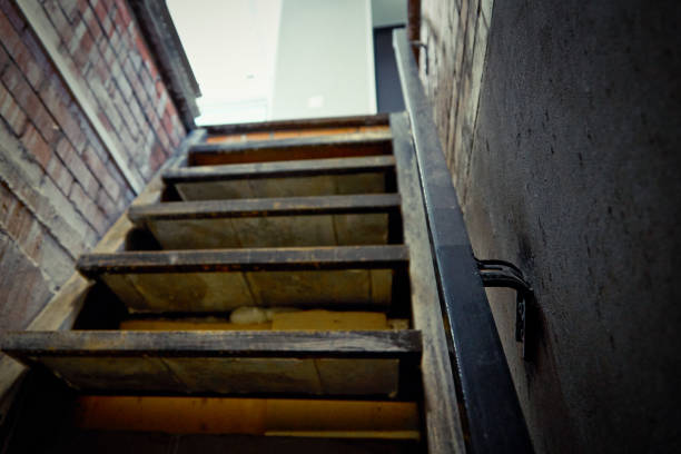 istock Exit from the brick cellar with a railing up the stairs to the light 1371985483