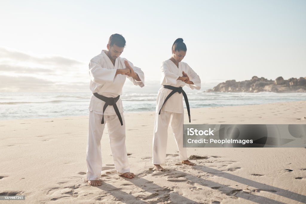 Full length shot of two young martial artists practicing karate on the beach A fighter must have honour Bowing Stock Photo