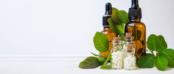 Homeopathic globules in small glass bottles on a white background. Homeopathy concept.