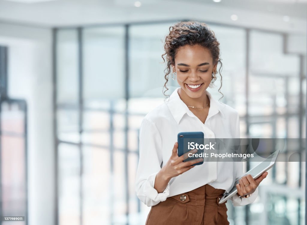 Cropped shot of an attractive young businesswoman sending a text while working in her office Woman in the office Businesswoman Stock Photo