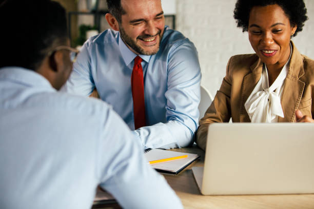 istock Cheerful business colleagues laughing at project data during a meeting 1371989103