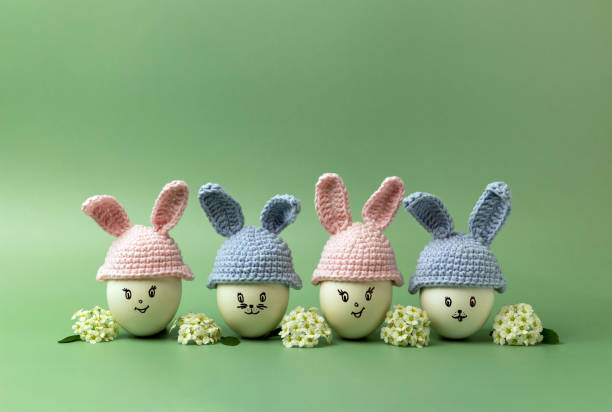 istock Creative composition with Easter bunnies made of eggs and flowers on a green background. 1371989757