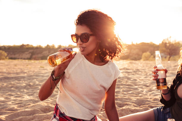 istock Young group of friends outdoors on the beach drinking beer. 1371990222