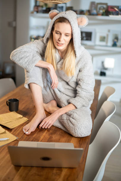 missing a friend during lockdown. woman doing video call in cute bear onesie - onesie imagens e fotografias de stock