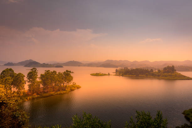 Lake Mutanda at sunset with view on the volcanoes mount Muhavuru and mount Gahinga in East Africa, along the border of Rwanda and Uganda. Lake Mutanda at sunset with view on the volcanoes mount Muhavuru and mount Gahinga in East Africa, along the border of Rwanda and Uganda.  Horizontal. democratic republic of the congo stock pictures, royalty-free photos & images