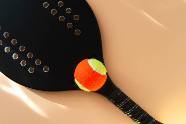 블랙 프로 비치 테니스 라켓과 베이지 색 배경에 공. 수평 스포츠 테마 포스터, 인사말 카드, 헤더, 웹 사이트 및 응용 프로그램 - tennis tennis racket racket tennis ball 뉴스 사진 이미지