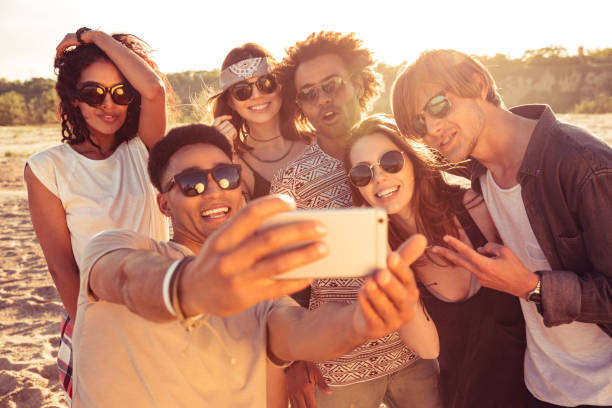 istock Excited young friends on the beach make selfie 1371993179