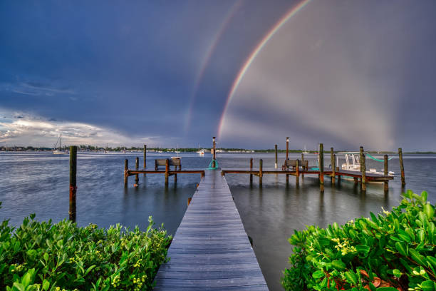 arcobaleno dopo una tempesta alla fine di un molo - rainbow harbor foto e immagini stock