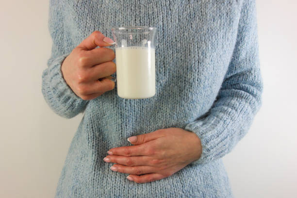 kobieta z bólem brzucha trzymająca szklankę mleka - peptic ulcer zdjęcia i obrazy z banku zdjęć