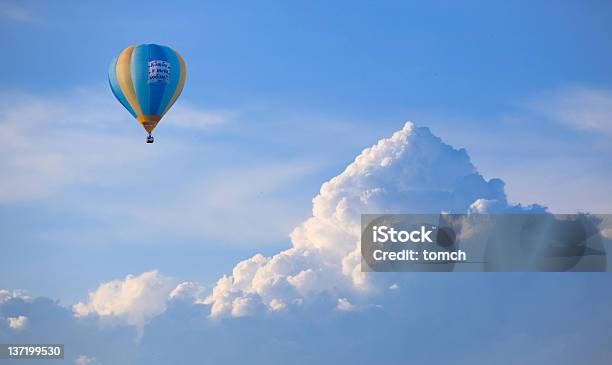 Yellow And Blue Hot Air Balloon Floating In The Cloudy Sky Stock Photo - Download Image Now