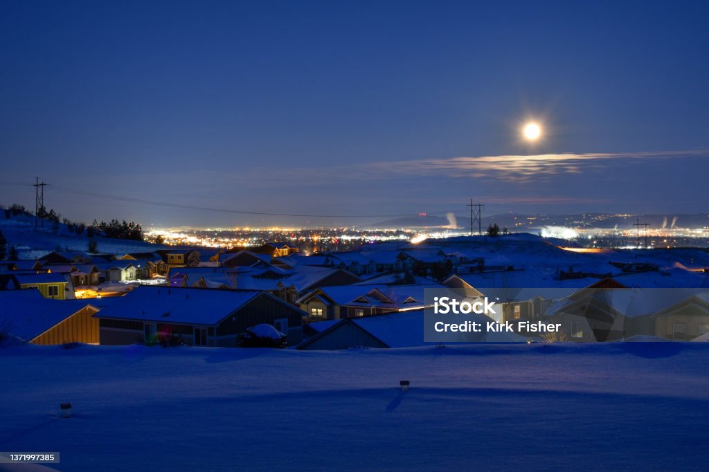 Early morning blue hour winter view from a suburban hillside subdivision overlooking the Spokane Valley, in the State of Washington, covered in snow. Spokane Stock Photo