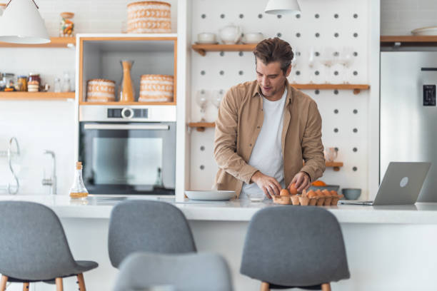 istock Mid adult man preparing eggs for breakfast in the kitchen. 1371997579