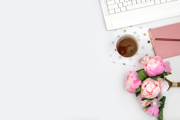 istock Modern woman's desktop, home office. Computer, cup of coffee and spring flowers on a light table. Minimal business concept, home comfort, 1372000415