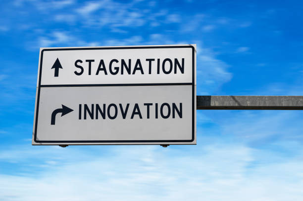 istock Road sign with words stagnation and innovation. 1372000547