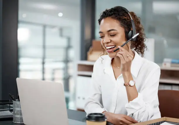 Photo of Cropped shot of an attractive young female call center agent working at her desk in the office