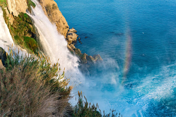 rainbow at the foot of a waterfall falling into the sea from a cliff, Lower Düden, Antalya rainbow at the foot of a waterfall falling into the sea from a cliff, Lower Düden, Antalya Duden stock pictures, royalty-free photos & images