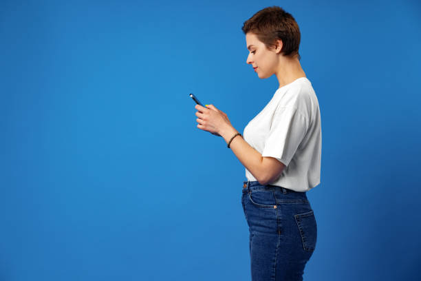 istock Happy nice girl using cellphone isolated over blue background 1372002151