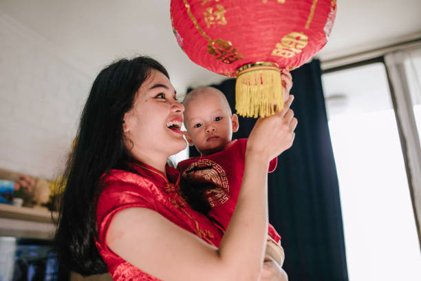 istock asian mother carrying her baby during imlek celebration 1372002200