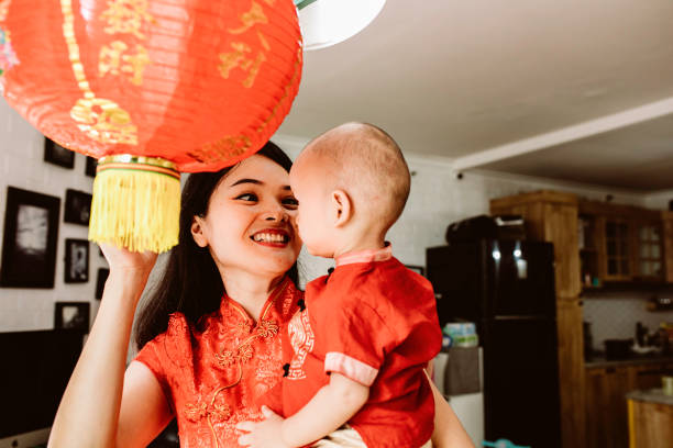 istock asian mother carrying her baby during imlek celebration 1372002254