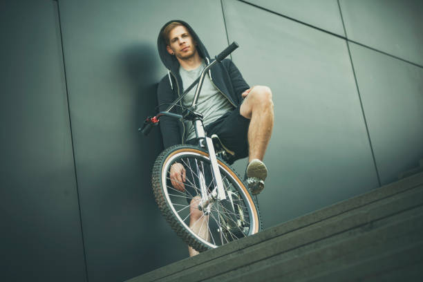 BMX rider taking a jump over a ramp and doing acrobatics in the air - risky past-time and fun activity