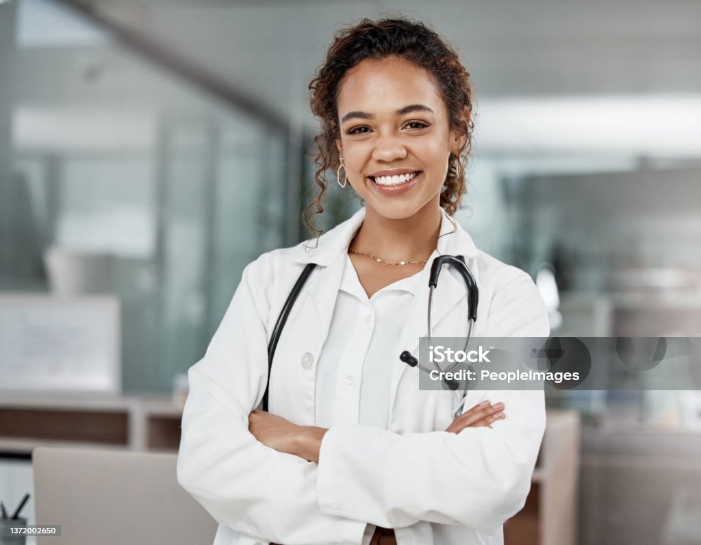 Cropped portrait of an attractive young female doctor standing with her arms folded in the office Woman in the office Doctor Stock Photo